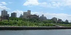 Pier 1 park with an expanse of lawn with trees and high rise buildings in the background