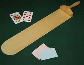 A baccarat palette and cards on a casino gambling table.