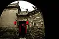 A door in a courtyard with red Chinese lanterns