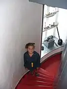 Interested visitor inside the lighthouse, stairs and artifacts