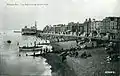 Piers supporting bandstand visible above beach, 1920s