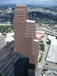 Large building with three, segmented tower setbacks, each with a steeply pitched roof line topped with a series of spires.