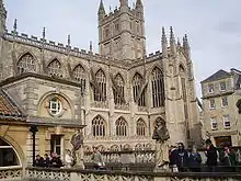 Yellow stone building with large arched windows and a tower.