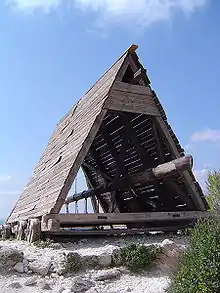 A wheel-mounted battering ram with a protective frame made of beams