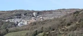 Exposed stone face of quarry, and buildings