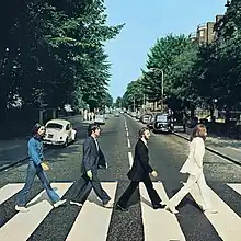 The cover of Abbey Road has no printed words. It is a photo of the Beatles, in side view, crossing the street in single file.