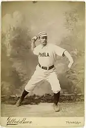 A baseball player is posing as if in the action of throwing a baseball.