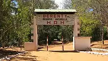 A dirt road runs under a decorated, arching sign demarcating the Berenty Private Reserve.