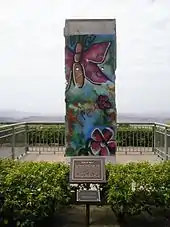 A chunk of cement, painted with natural shapes, such as insects and flowers.