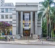 Photograph of the facade of a large stone building with unadorned cuboidal columns