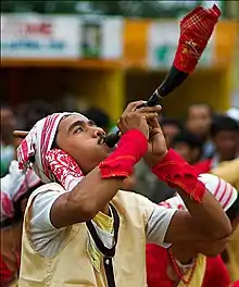 A Bihu dancer with a horn.