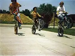 Wheelies by seated and standing cyclists