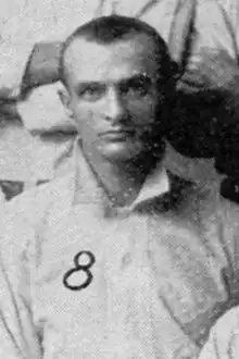 A portrait of a man wearing a light baseball jersey