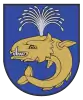 A coat of arms depicting a sea creature with sharp teeth, one protruding bottom tooth, and a blowhole spewing water