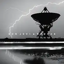 A black-and-white image of a radio telescope dish aimed straight up, silhouetted against a cloudy sky, with lightning arcing down to the ground.