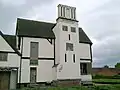 The hunting lodge from the west. The stucco that covered the original patchwork of brick and daub has false windows painted on.