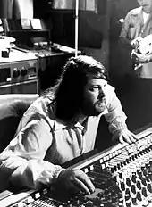 Wilson seated at a mixing board