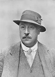 Sepia portrait photograph of middle-aged gentleman in suit and hat in 1920