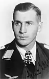 A man wearing a military uniform with an Iron Cross displayed at the front of his uniform collar.