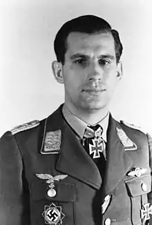 A man wearing a military uniform with an Iron Cross displayed at the front of his uniform collar.