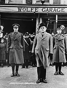 Three men standing in front of a building named "Wolfe Garage"