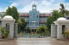 Three-story building with central column, framed with palm trees