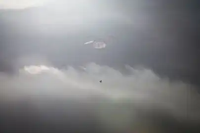 Dragon descending under parachute