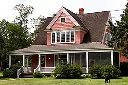 Pink house with large gables and a porch.