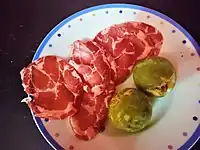 Slices of capocollo di Martina Franca served with figs