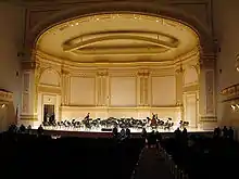 the interior of a nineteenth century concert hall looking from the auditorium towards the platform