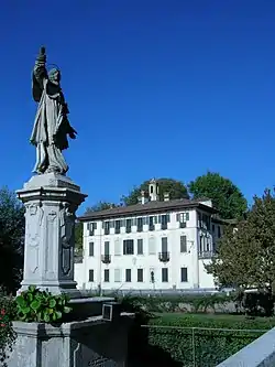 Statue of St. Charles Borromeo and Villa Visconti Maineri.