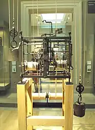 large open clock mechanism in a glass case