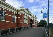 A paved ramp heading up towards the historical station building on platform 4