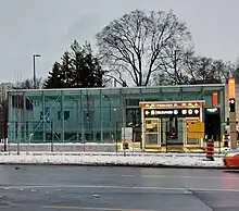 Photo of a largely completed modern light rail station entrance with glass panelling.