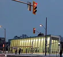 Photo of a modern, glass-panelled light rail station entrance under construction which appears largely complete