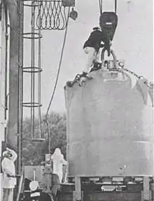  Large conical structure on a pulley with a man on top and two near the base.