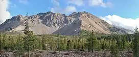 Crumbling breached cone mountain with exposed gray surface