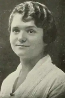 A young white woman wearing a white blouse, with her hair in finger waves