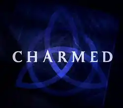 A dark blue triquetra over a darker blue background that fades to black near the edges with the word .mw-parser-output span.smallcaps{font-variant:small-caps}.mw-parser-output span.smallcaps-smaller{font-size:85%}charmed in capital letters across the center using a light-green, medium-sized font