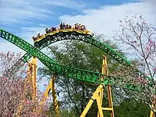 One of the Cheetah Hunt trains is photographed traversing over a bunny hill. In the opposite direction is another track section before the heartline roll.