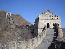 A stone wall going uphill with towers spaced along it