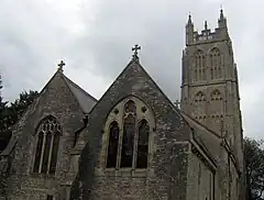 Stone two bay building with prominent ornamental tower behind