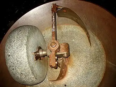 Old Millstone equipped with windrow ploughs, used to grind cocoa beans