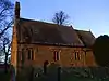 A small stone church with lancet windows and a bellcote