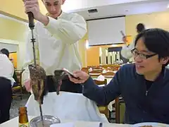 Waiter serves rodízio style in Japan.