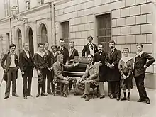 outdoor group photograph of a small class of students with their professor