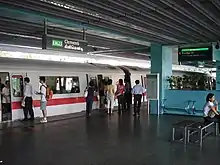 A white train halting at a platform