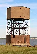 View of a tall hexagonal building comprising a brick structure standing on an open framework above another brick structure