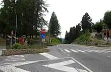 An intersection of a road with lots of white road paint.