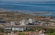 On the right a Liebherr top-slewing crane of the EC-H Litronic series